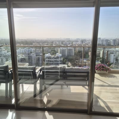 נוף עירוני מבעד לחלון זכוכית עם תריסים