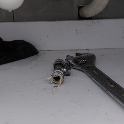 כלי עבודה וצינור מתחת לכיור