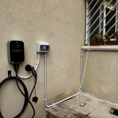 מטען חשמלי מותקן על קיר חיצוני ליד חלון