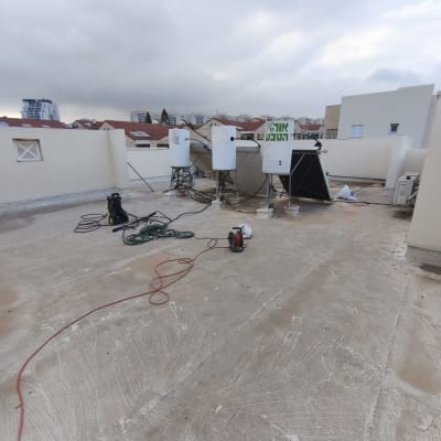 גג עם ציוד ואביזרים על רקע בניינים