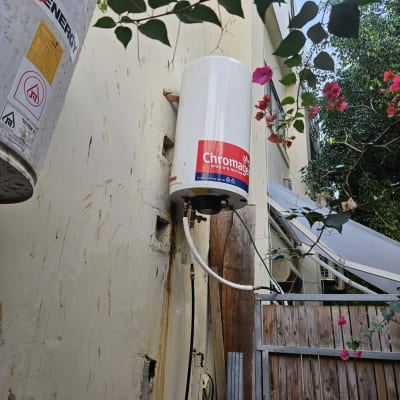 דוד שמש מותקן על קיר עם צינורות מחוברים