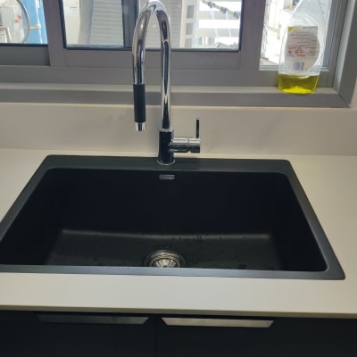 כיור שחור עם ברז על משטח שיש לבן