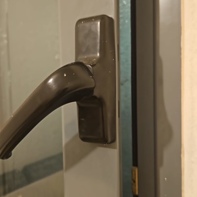 ידית חלון מתכתית על תריס אפור