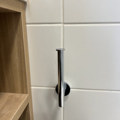 צינור כרום מותקן על קיר אריחים לבנים