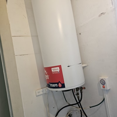 דוד שמש עם צינורות וחיבורים חשמליים על קיר