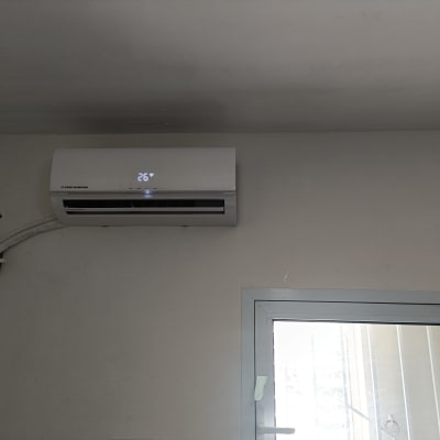 מזגן מותקן על קיר עם תצוגת טמפרטורה 26 מעלות