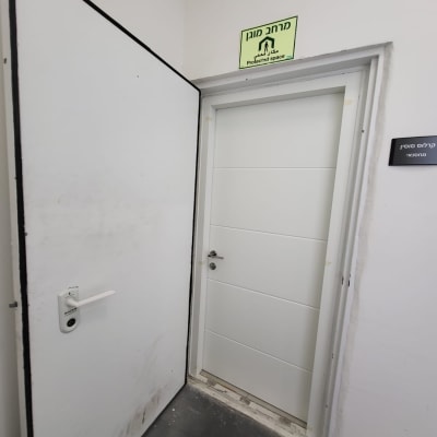 דלת לבנה עם שלט מרחב מוגן