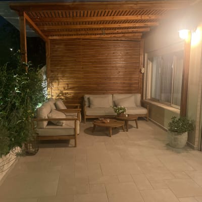 פינת ישיבה מעץ עם ספות ושולחן בגינה