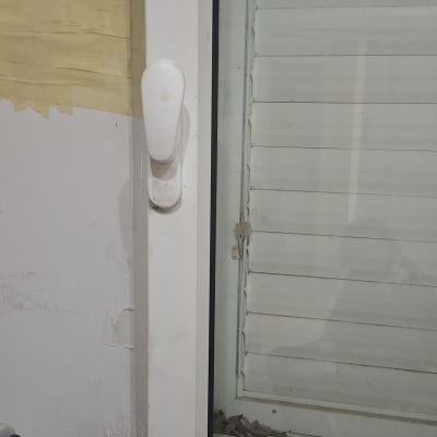 חלון עם מסגרת לבנה וידית פלסטיק לבנה