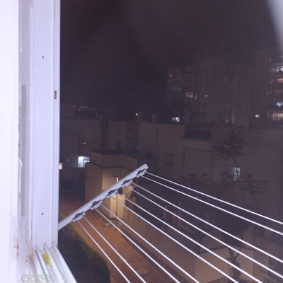 חבלי כביסה מחוברים לחלון פתוח בלילה