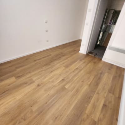 רצפת פרקט עץ בחדר ריק עם קירות לבנים