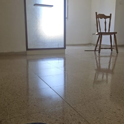 רצפה מבריקה עם כיסא ומטאטא בחדר ריק