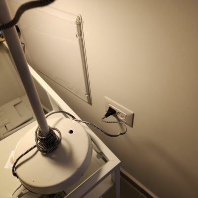 מנורה עם כבל מחובר לשקע חשמל בקיר