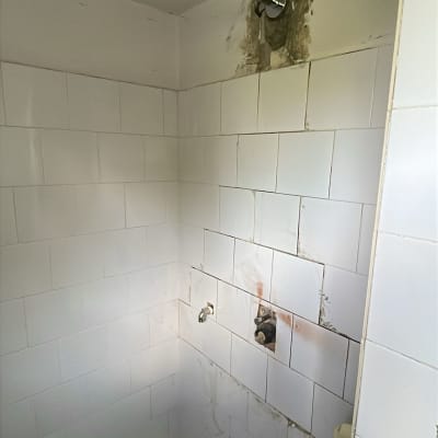 חדר אמבטיה עם אריחים לבנים וברזים חשופים