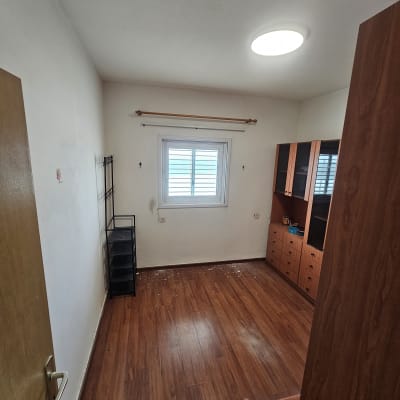 חדר ריק עם רצפת עץ וארון קיר