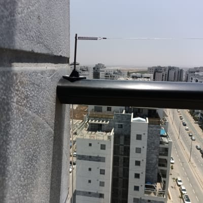 חוט מתכת עם קפיץ למניעת יונים על מעקה מרפסת