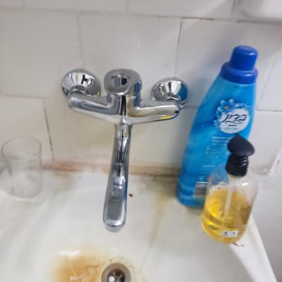 ברז כיור עם כתמי חלודה סביב הניקוז