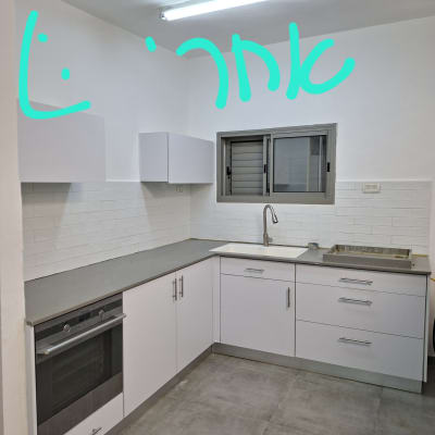 מטבח חדש עם ארונות לבנים וכיור