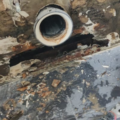 צינור חשוף עם קיר מתקלף וכלי עבודה על הרצפה