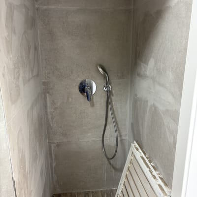 מקלחת עם קיר אריחים ומקלחת יד