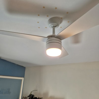 מאוורר תקרה עם תאורה דולקת על תקרה לבנה