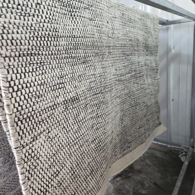 שטיח תלוי לייבוש על מתקן מתכת