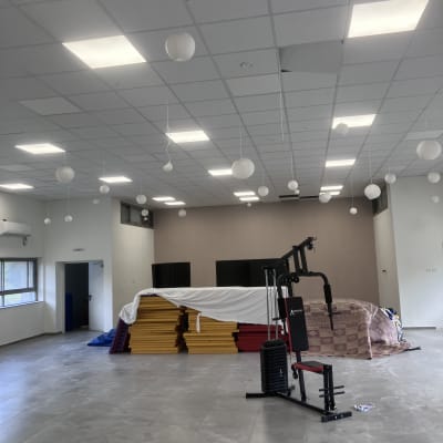 חדר עם תקרה לבנה, מנורות תלויות, קיר צבוע.