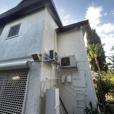 קיר חיצוני עם מזגן וצמחייה מסביב