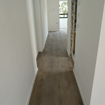 רצפת פרקט עץ כהה במסדרון צר ולבן