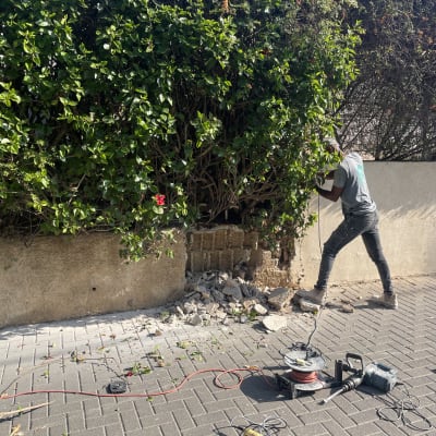 חשמלאי עובד עם כבל חשמל וכלי עבודה על הקרקע