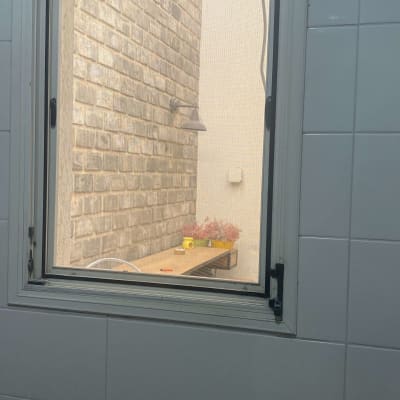 חלון עם מסגרת מתכת, קיר לבנים בחוץ