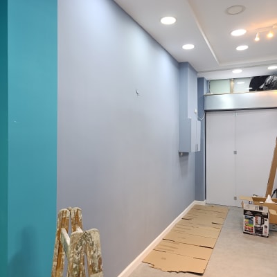 קיר צבוע בכחול עם סולם ומברשת צבע