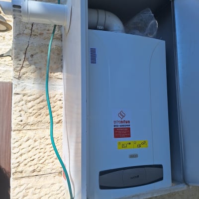 דוד גז מותקן על קיר עם צינור פליטה