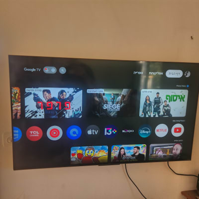 טלוויזיה מותקנת על קיר עם תצוגת אפליקציות שונות