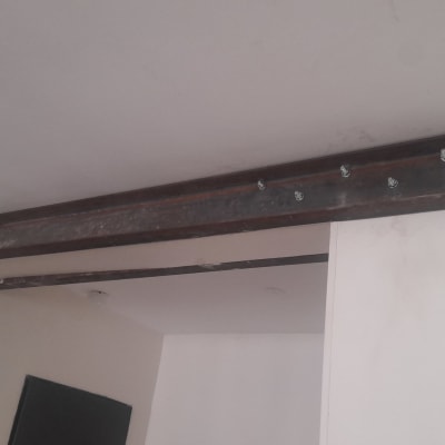 קורת פלדה מחוברת לתקרה עם ברגים