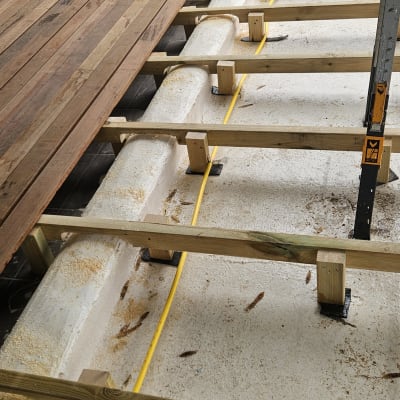 עובד מתקין רצפת עץ על מסגרת עץ