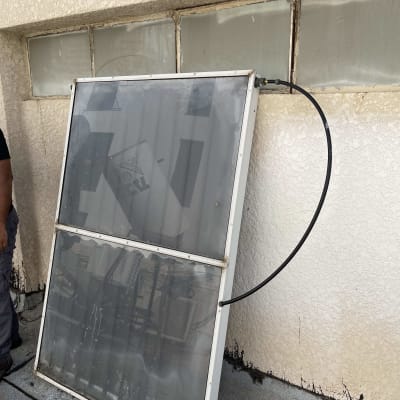 קולטן שמש עם צינור מחובר על גג