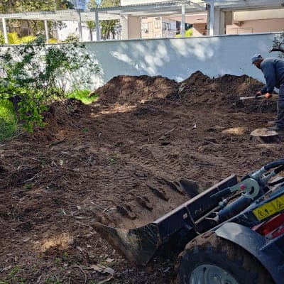 עבודת גינון עם כלי חפירה ואדם בשטח