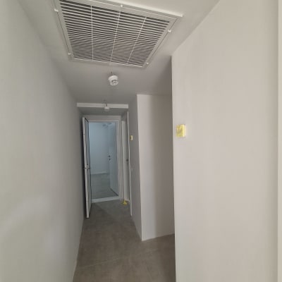 מסדרון צבוע בצבע לבן עם דלת פתוחה