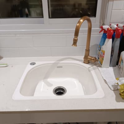 כיור מטבח עם ברז זהב ומוצרי ניקוי