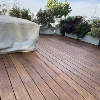 wooden deck with covered furniture and potted plants