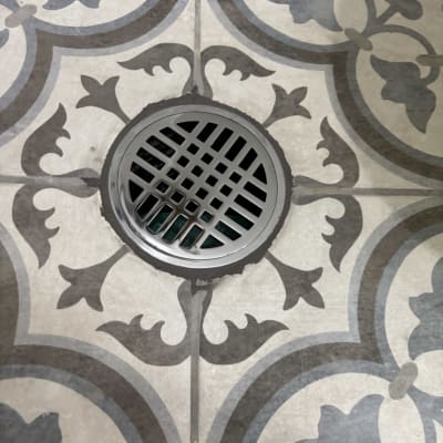 רצפת אריחים עם ניקוז מתכת עגול