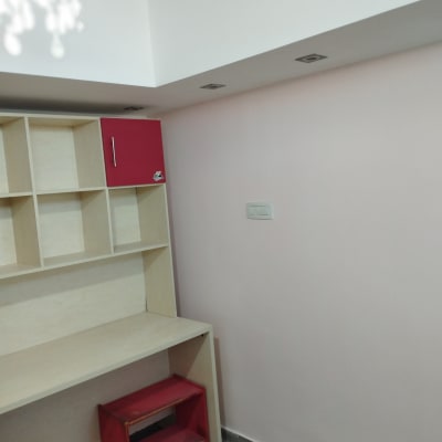 קיר צבוע בצבע ורוד בהיר עם שולחן עץ