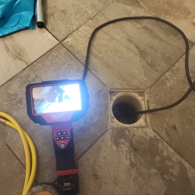 מצלמה תרמית עם כבל ליד פתח ניקוז ברצפה