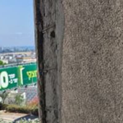 קיר בטון עם סימני איטום ליד נוף עירוני