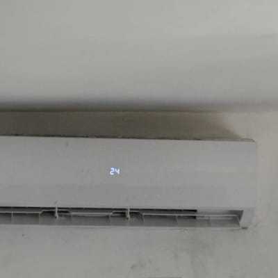 מזגן מותקן על קיר עם תצוגת טמפרטורה 24 מעלות