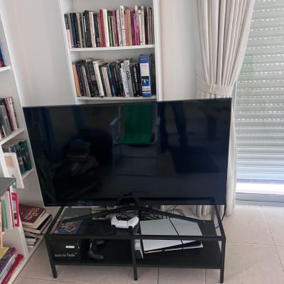 טלוויזיה על שולחן עם שלט משחק וחוטים