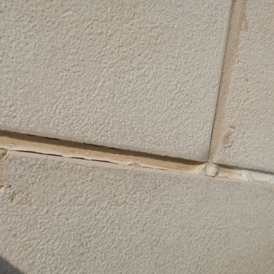 תקריב של קיר בטון עם סדקים ותפרים גלויים