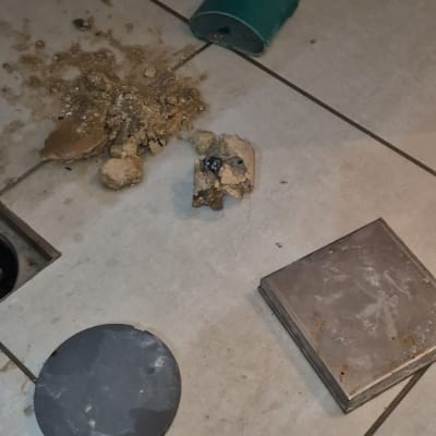 צינור ירוק שבור על רצפה עם לכלוך