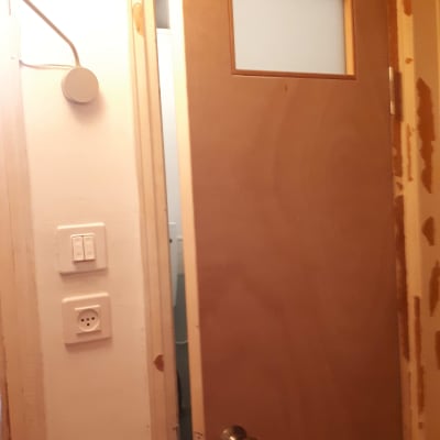 דלת עץ עם חלון קטן וידית מתכת